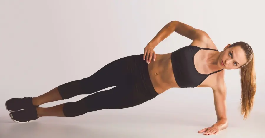 Mulher em posição de prancha lateral, demonstrando um exercício com peso corporal para fortalecer o core e melhorar a estabilidade.